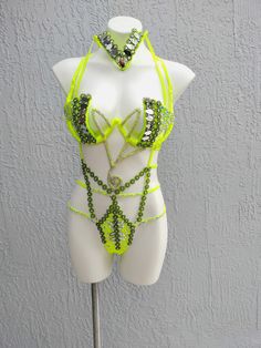 a white mannequin with green beads on it's chest and two bras