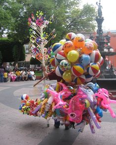 a woman is holding balloons in the shape of animals