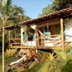 a small house with hammocks on the porch