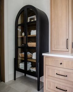 an arched cabinet in the corner of a bathroom