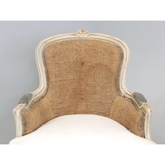 an upholstered headboard and foot rest on a white bed frame with beige linen