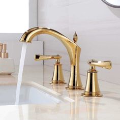 the faucet is gold in color, and it has two handles on each side