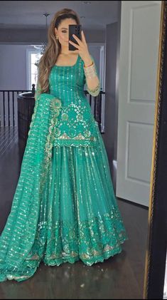 a woman in a green gown taking a selfie