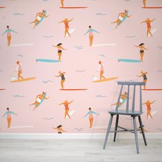 a chair in front of a pink wall with surfers on it