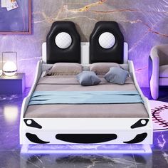 a bed with two black and white headboards on top of it in front of a purple wall