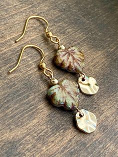 Czech Glass Maple Leaf Dangle Earrings are the perfect accessory for nature lovers, featuring a rustic look with a gold color wavy disc. These boho leaf earrings with stainless steel hooks make a beautiful addition to your fall jewelry collection. 𝗗𝗘𝗧𝗔𝗜𝗟𝗦 ✨ Materials:  Gold Color Wavy Circles and round beads, gold plated hypoallergenic stainless steel earring hooks, and czech glass rustic picasso maple leaf beads  ✨ Size:  Approximately 1 1/2 inches long (see picture for measurement detai Everyday Leaf-shaped Jewelry With Matching Earrings, Nature-inspired Leaf-shaped Jewelry With Matching Earrings, Nickel-free Leaf-shaped Nature-inspired Jewelry, Handmade Leaf-shaped Everyday Jewelry, Everyday Handmade Leaf-shaped Jewelry, Nature-inspired Leaf Jewelry For Everyday, Everyday Nature-inspired Leaf Jewelry, Earthy Gold Dangle Jewelry, Hypoallergenic Leaf-shaped Nature-inspired Jewelry