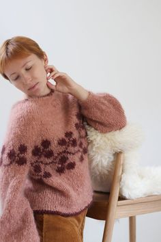 a woman sitting on a chair next to a stuffed animal and talking on the phone