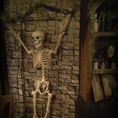 a skeleton standing in front of a brick wall