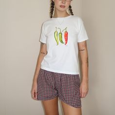 Turn up the heat with our Chili Pepper Baby Tee! This hot number features a trio of brightly colored chili peppers that add a kick of style to any casual look. Revamp your wardrobe with Everlace Designs' exclusive collection of essential tees, cozy hoodies, and playful baby tees in signature prints. Shop now for vibrant, cheeky designs perfect for any casual occasion. Elevate your everyday style with Everlace! Disclaimer: Product Images  Please note that the images displayed are digital mock-ups Red T-shirt For Summer Loungewear, 90s Style Relaxed Fit Cotton Top, Fitted Cotton Shirt For Loungewear, Red Y2k Cotton T-shirt, Red Y2k Style Cotton T-shirt, Retro Cotton Tops For Loungewear, 90s Style Red Cotton Shirt, Red Short Sleeve Tops For Loungewear, Cute Red Relaxed Fit Top