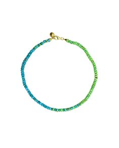 a blue and green beaded bracelet on a white background