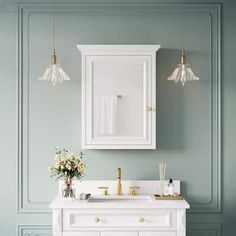 a white bathroom vanity with two lights and a mirror above it, against a blue wall