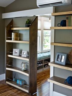 an empty room with shelves and pictures on the wall