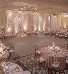 a banquet hall with tables, chairs and chandeliers set up for a formal function