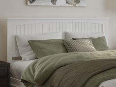 a bed with two cats on the wall above it, and pillows in front of it