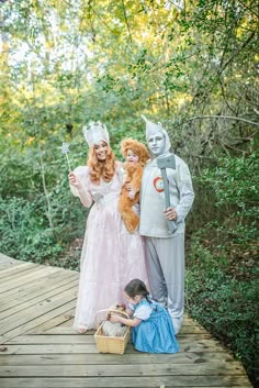 three people in costumes standing on a wooden platform