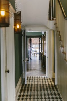 the hallway is lined with black and white checkered flooring, along with an open door leading to another room