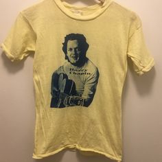 Vintage 1970s Yellow Harry Chapin T-Shirt Size S Genuine Vintage Harry Chapin Shirt. Overall Great Condition, Small Separation/ Hole On The Seam On The Back Near The Neck On The Shoulder. Can Be Mended Easily. Barely Worn, Has Been In My Mother In Laws Closet Unworn Since The 70s. Tags: Vintage, Vtg, Band Tee, Graphic Tee, 70s, 1970s. Vintage Yellow Crew Neck Shirt, Vintage Yellow Top With Screen Print, Vintage Yellow Tops With Screen Print, Vintage Yellow Short Sleeve T-shirt, Harry Chapin, In Laws, The 70s, My Mother, Band Tees