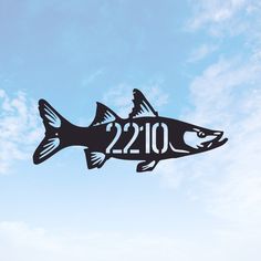 a metal fish with the year 2012 on it's side flying in the sky