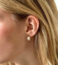 Introducing our exquisite collection of Sterling Silver Tiny Bean Stud Earrings, designed with the utmost attention to detail and crafted to perfection. These gold minimalist earrings offer a delicate and elegant aesthetic, making them a must-have for every fashion-forward woman. We understand the importance of comfort, especially for those with sensitive ears. That's why these dainty earrings are hypoallergenic, ensuring a comfortable and irritation-free experience. The sterling silver construc Huggie Plug Earrings As Gift, Elegant Huggie Plug Earrings As Gift, Classic Tarnish Resistant Plug Earrings As Gift, Gift Huggie Clip-on Earrings, Huggie Clip-on Earrings For Gifts, Huggie Plug Earrings For Gifts, Classic Drop Wrap Earrings For Pierced Ears, Classic Drop Wrap Earrings, Classic Hypoallergenic Earrings As A Gift