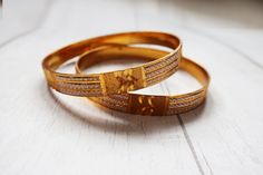 "A pair of nice gold tone metal bracelets. They have a nice weight to them and have no makers marks. The bracelets measure 0.4\" wide and 2.5\" across.  All jewellery is shipped in a gift box. PROCESSING AND SHIPPING TIMES: Please check my shop policies for latest info on shipping https://www.etsy.com/uk/shop/TrudysStoreClothing/policy?ref=shopinfo_policies_leftnav Thanks for looking! WEB: www.trudysstore.com FACEBOOK: www.facebook.com/TrudyStore INSTAGRAM: @trudys_store TWITTER: @silkepants PINTEREST: www.pinterest.com/silkepants" Elegant Gold Band Bangle, Gold Etched Bracelet For Wedding, Gold Etched Cuff Bracelet For Wedding, Gift Gold Etched Cuff Bracelet, Adjustable Etched Gold Bangle, Adjustable Gold Etched Bangle, Formal Gold Brass Bangle, Traditional Etched Yellow Gold Bangle, Gold Etched Bracelet Jewelry