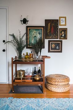 a shelf with bottles, glasses and other items on it in front of a door