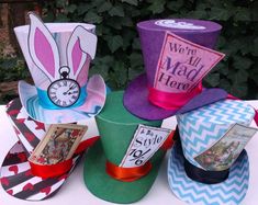 several hats are sitting on top of each other at a table with flowers in the background