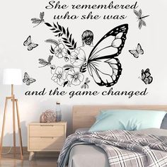 a bedroom with a bed, nightstand and wall decal that says she remembers who she was