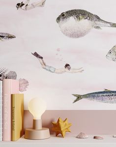 a wall with fish and sea creatures painted on it's walls, along with bookshelves