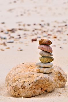 a stack of rocks sitting on top of a sandy beach