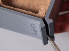 a close up of a piece of wood being cut with a pair of tongs