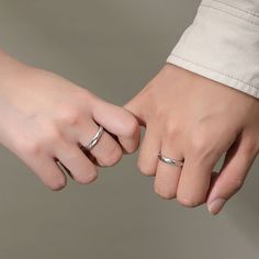 two hands holding each other with wedding rings on their fingers and one hand touching the other