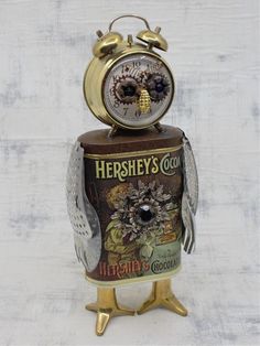 an owl clock sitting on top of a tin can