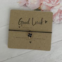 a card with a clover on it next to pink flowers