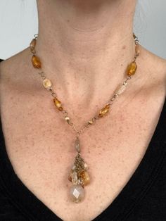 Handmade natural gemstone beaded necklace for person with a petite neck. This is an antiqued gold-tone single chain necklace comprised of polished citrine beads, golden glass beads, multicolored Japanese glass seed beads. This beaded necklace has a pendant of a cluster of citrine beads, multicolored Japanese glass seed beads and rutilated quartz and is closed with a antiqued gold-tone toggle-clasp. This is a golden, light yellow and amber colored handmade chunky necklace with beads and gemstones. Characterized by a free-spirited and unconventional look featuring natural materials, asymmetrical design, and a mix of colors and textures, this small bohemian chic necklace can be worn whenever someone wants to add a touch of boho flair to their outfit, whether it's for a casual daytime outing o Antique Beaded Pendant Jewelry, Artisan Brass Jewelry With Gemstone Beads, Artisan Wire Wrapped Dangle Necklace, Antique Beaded Pendant Necklace, Yellow Teardrop Bohemian Jewelry, Bohemian Dangle Necklace With Faceted Beads, Healing Brass Jewelry With Gemstone Beads, Spiritual Gold Beaded Lariat Necklace, Antique Handmade Dangle Necklaces