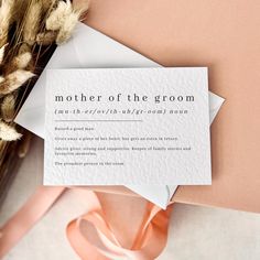 a mother of the groom card sitting on top of a table next to some dried flowers