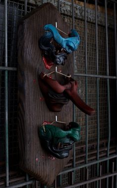 there are three fake shoes hanging on the wall in front of a caged area