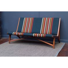 a striped couch sitting on top of a rug next to a blue wall in a living room