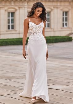 a woman in a white dress is walking down the street with her hand on her hip