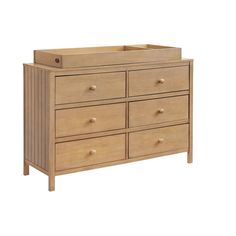 a wooden dresser with six drawers and two baby cribs in the bottom drawer