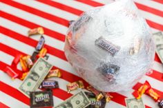 candy bar wrapped in plastic and sitting on top of a table with money scattered around it