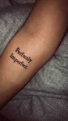 a person with a tattoo on their arm that says perfectly imperfect