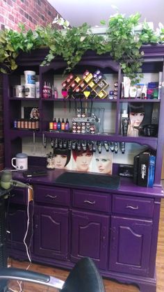 a room with purple furniture and shelves filled with hair care products on top of it