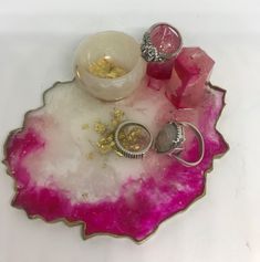 three rings sitting on top of a piece of pink and white rock with gold flakes