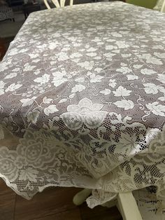 an image of a table cloth with white flowers on it in the middle of a room