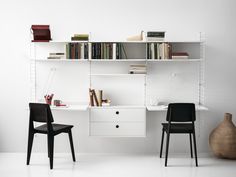 two black chairs sitting in front of a white desk