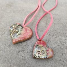 These raku pendants are designed for mother and daughter to feel a connection to one another as well as to mother earth. They are hand sculpted from clay, a pure earth's source,  and fired in a raku ritual which harnesses the elements, earth, air, water and fire. These necklaces will offer protection against negative Energy. They have pink and a silver luster glazes made from pure oxides. Water And Fire, Elements Earth, Heart Pendants, Mother And Daughter, Negative Energy, Mother Earth, Mother Daughter, Heart Pendant, Ritual