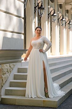 a woman in a white dress is standing on some steps and posing for the camera