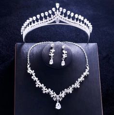 A delicate three-piece bridal jewelry set for the romantic bride! Adorned with intricately faceted cubic zirconia that capture the light from every angle with a perfectly translucent appeal, the pieces are rhodium plated for a flawless finish which enhances the intricate detailing and conveys a modern take on old elegance. Necklace: 17" long (approx. 43.2cm) with a 2" extension chain (approx. 5cm) for comfortable sizing (if you would like it longer, please include a note with the preferred lengt Wedding Jewelry With Crown Design, Dazzling White Gold Jewelry Sets For Wedding, Elegant Hand Set Bridal Sets For Wedding, Cubic Zirconia Bridal Set With Sparkling Stones For Wedding, Dazzling Cubic Zirconia Bridal Sets For Wedding, White Sparkling Stones Jewelry Set For Wedding, Hand-set Cubic Zirconia Bridal Sets For Wedding, Crystal Bridal Sets With Diamond Accents For Wedding, White Crystal Bridal Sets With Elegant Design