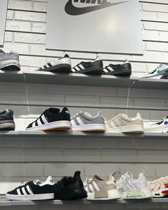 many different types of shoes on display in a shoe store, some with white and black stripes