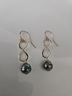 This captivating 14k gold-filled earrings are adorned with a resplendent figure-eight design , a symbol of infinity, and mesmerizing baroque 8.4mm Tahitian pearls that cast a radiant glow upon every movement. Elegant Hypoallergenic Infinity Earrings, Elegant Handmade Infinity Jewelry, Gold Infinity Earrings For Formal Occasions, Elegant Gold Infinity Earrings, Elegant Nickel-free 14k Gold Filled Pearl Earrings, Infinity Earrings, Tahitian Black Pearls, Pearl Dangle Earrings, Gold Filled Earrings